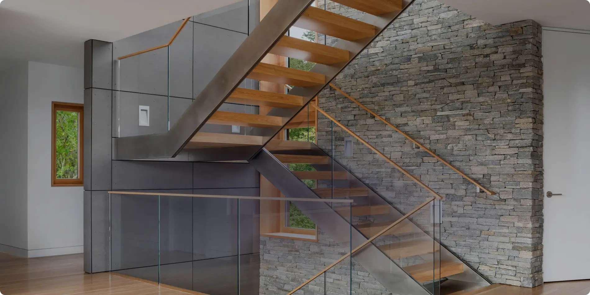 Contemporary floating wooden staircase with glass railings, featured on the Modern Stairs banner.